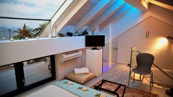 Un espacio habitable moderno y funcional con tragaluz, televisor de pantalla plana y una zona de estar acogedora.