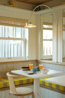 Un comedor con una mesa, sillas y un banco. Hay dos cuencos y dos vasos sobre la mesa.