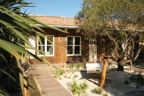 A wooden house with a tiled roof, a hammock, and a tree in the yard. - Hôtel des Dunes (Lège-Cap-Ferret)