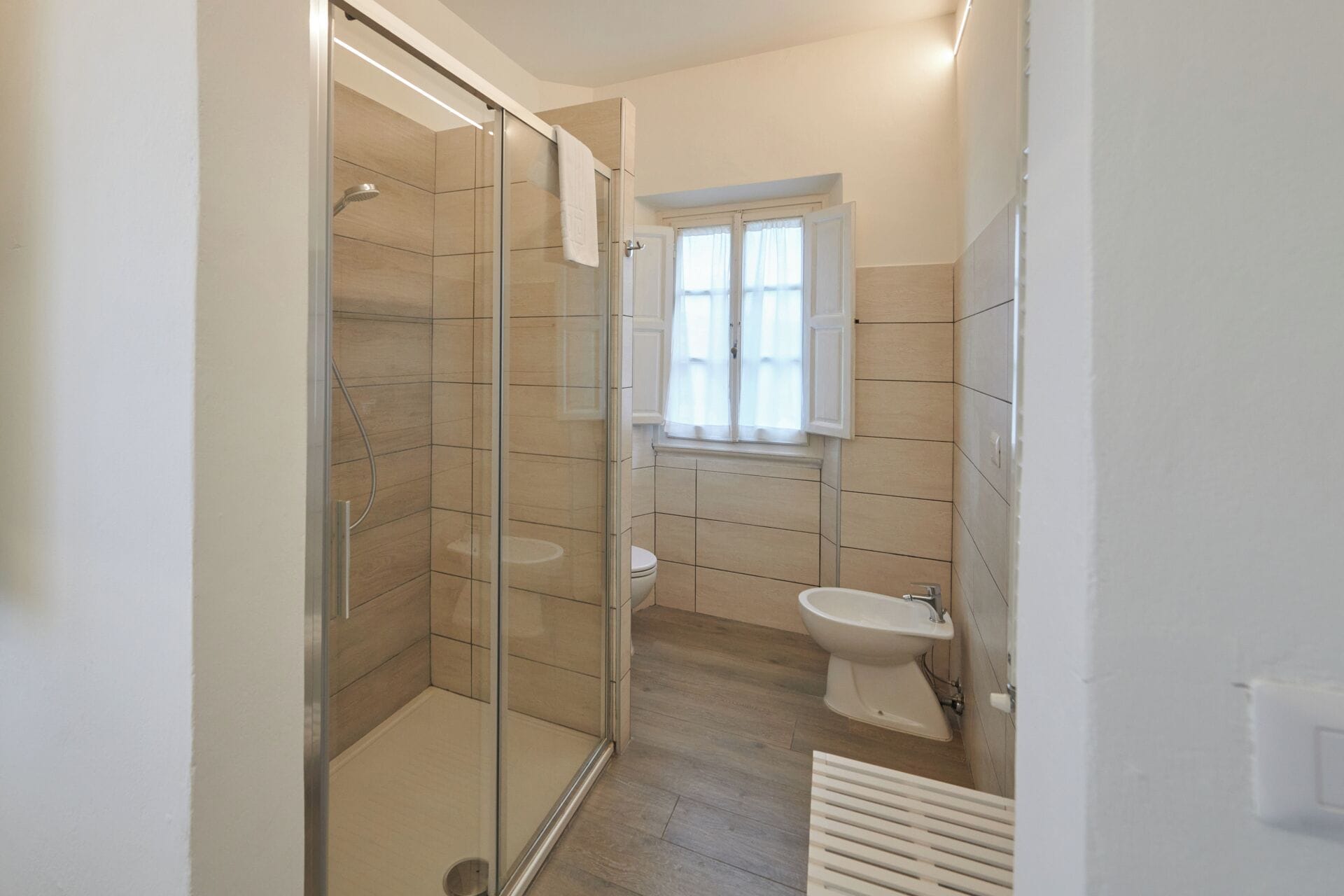 Un baño moderno con ducha envuelta en vidrio, inodoro y bidé.