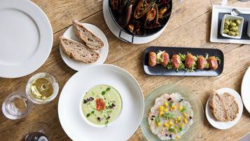 A dining table with various dishes, including seafood, bread, and a bowl of soup.