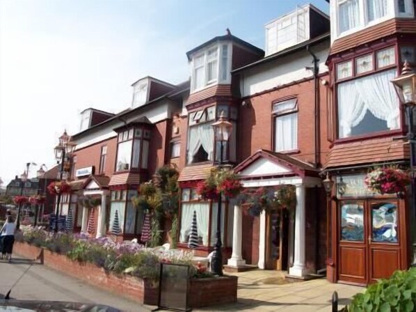 A row of red brick houses with bay windows and white trim.