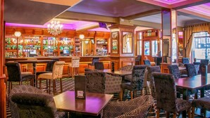 A bar area with wooden furniture, a bar counter, and a chandelier. - The Revelstoke Hotel (Bridlington)