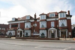 A row of red brick buildings with bay windows and a central entrance.