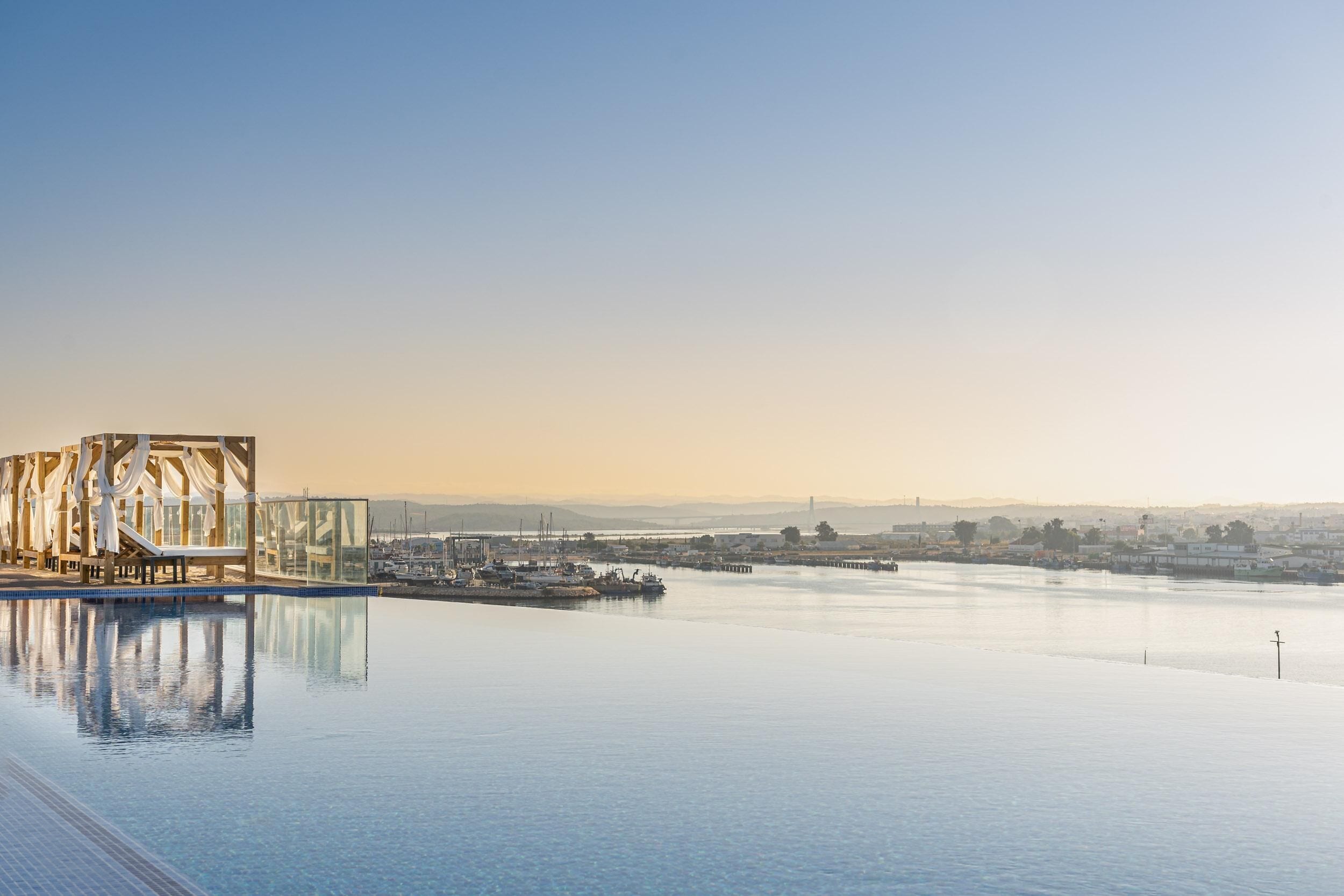An infinity pool with a clear view of the marina and distant cityscape.