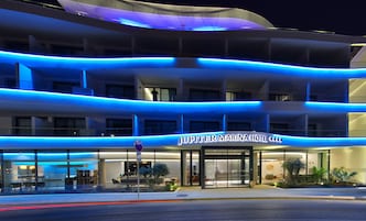 A hotel with a modern design, featuring multiple balconies and a prominent entrance.