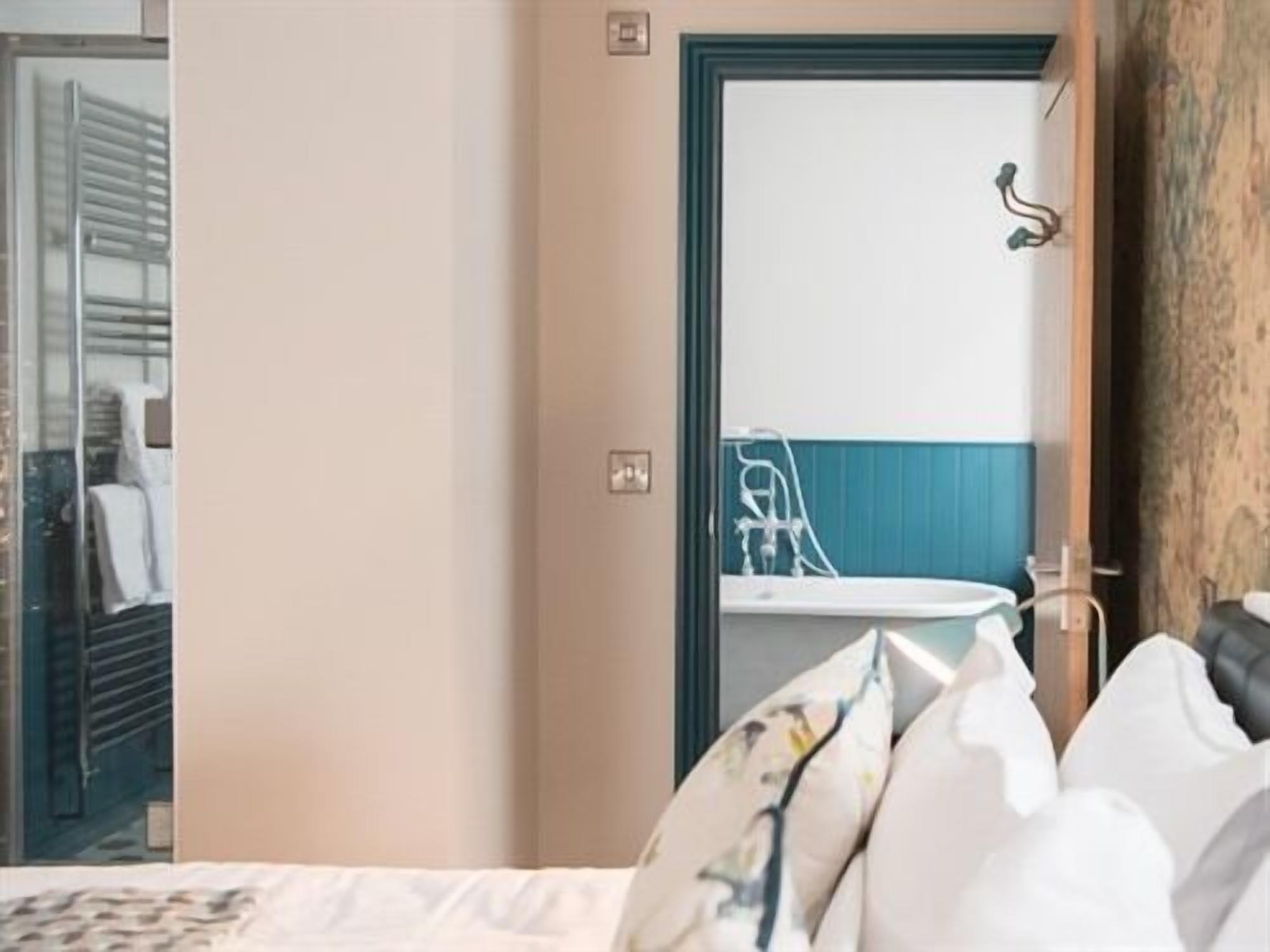 Una habitación de hotel con cama, espejo, lavamanos y armario.