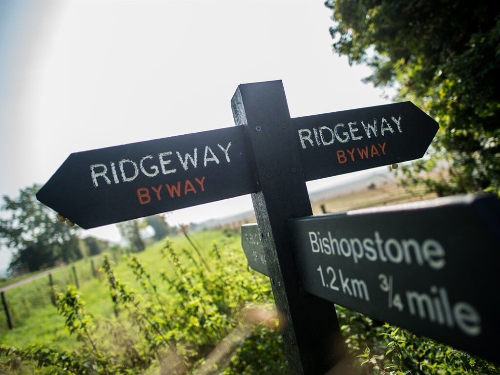 Ein Wegweiser mit den Beschriftungen 'Ridgeway Byway' und 'Bishopstone 1,2 km'.