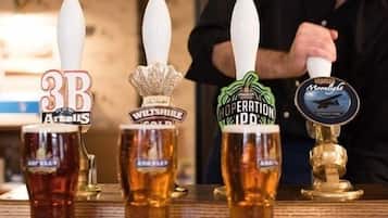 Un bar équipé de quatre tireuses, chacune portant le nom d'une marque de bière différente.