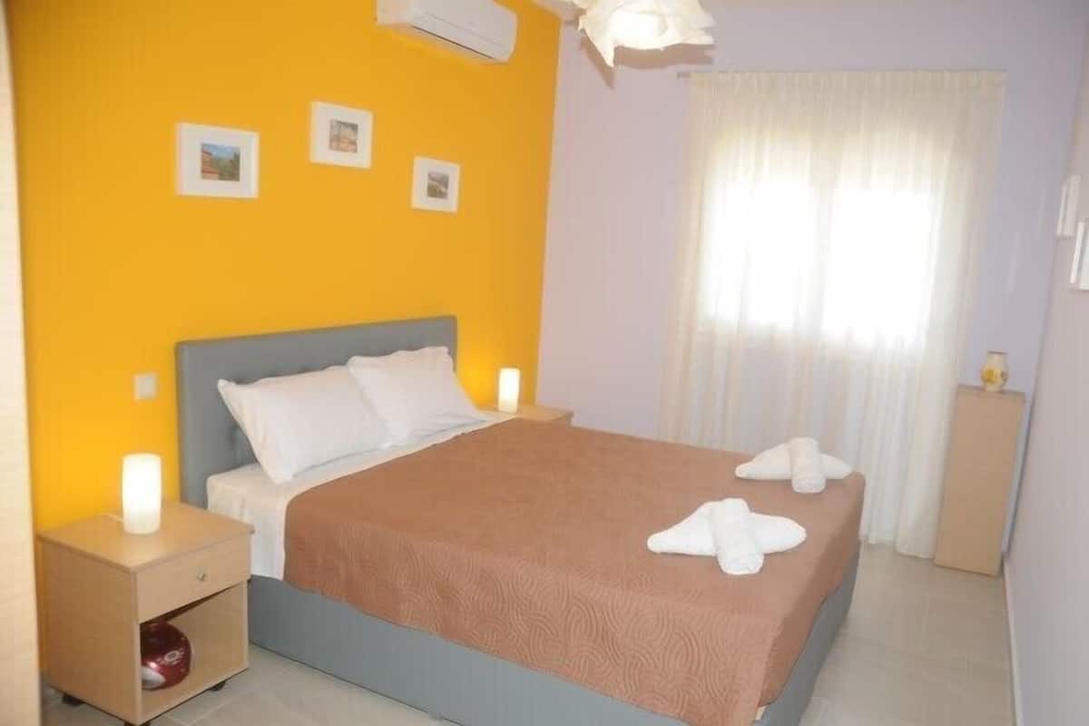 Une chambre à coucher avec un lit, des tables de chevet et une fenêtre avec des rideaux.