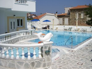 室外游泳池，池畔遮阳伞，日光浴躺椅