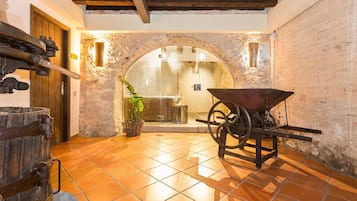 Step into a charming room with a traditional design, featuring a large arched doorway, a wooden barrel, and a potted plant.