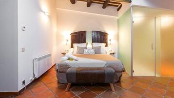 Un dormitorio con cama, radiador, techo de madera y puerta.