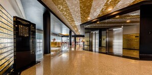 A hotel corridor with a polished floor, a directory on the left, and elevators on the right. - Aurea Fátima Hotel Congress & Spa (Ourem)