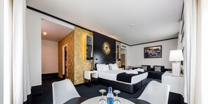 A hotel room with a bed, bedside tables, a desk, and a chair.