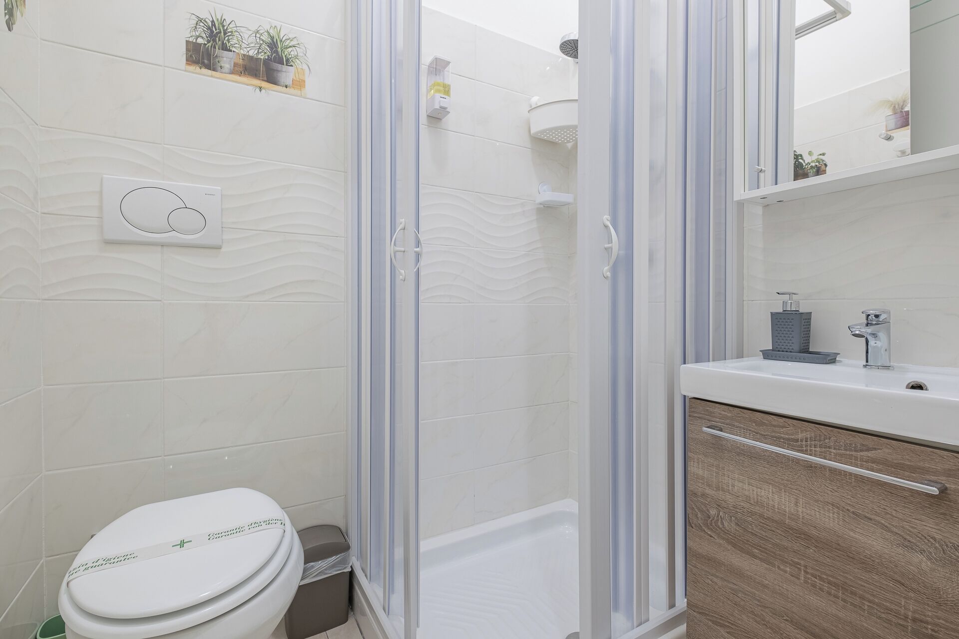 A modern bathroom with a shower enclosure, toilet, and sink.