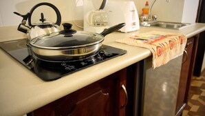 Une cuisine équipée d’une cuisinière, d’une bouilloire, d’une machine à café, d’un grille-pain et d’un évier.