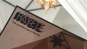 Skilt for HAYE, et gæstehus i Beirut, med en stjernestyllet lampe i baggrunden.
