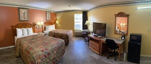 A hotel room with two beds, a desk, a chair, a television, a mirror, and a small refrigerator. - Mountain Inn & Suites Dunlap (Dunlap)