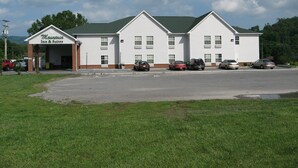 A two-story Mountain Inn & Suites with a parking lot in front. - Mountain Inn & Suites Dunlap (Dunlap)