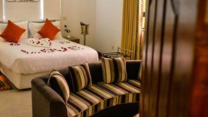 Una habitación de hotel moderna con cama, sofá, un panel decorativo y cortina.