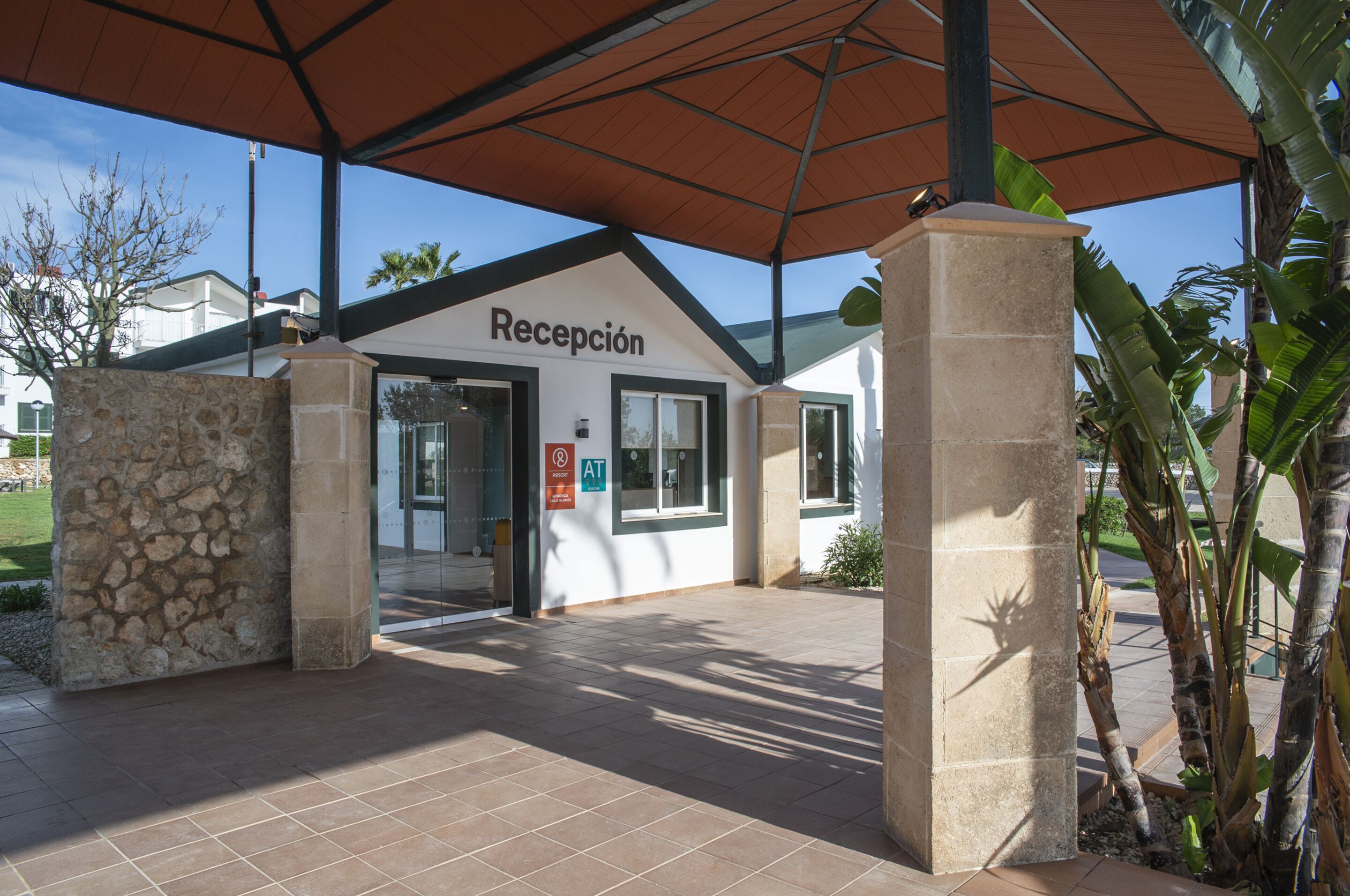 A reception area with a stone wall, a tiled floor, and a sign indicating an accessible entrance.