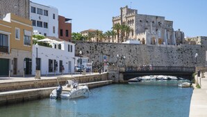 A canal with boats, a bridge, and historic buildings. - Pierre & Vacances Menorca Cala Blanes (Ciutadella de Menorca)
