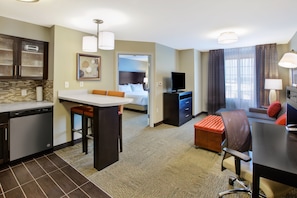 Une chambre d’hôtel équipée d’une kitchenette, d’un coin repas, d’un canapé, d’une télévision et d’une salle de bain.