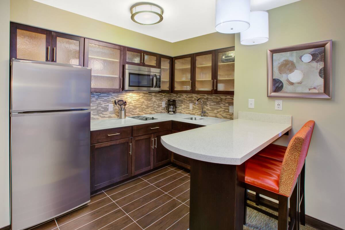 A modern kitchen with a stainless steel refrigerator, a microwave, and a coffee maker.
