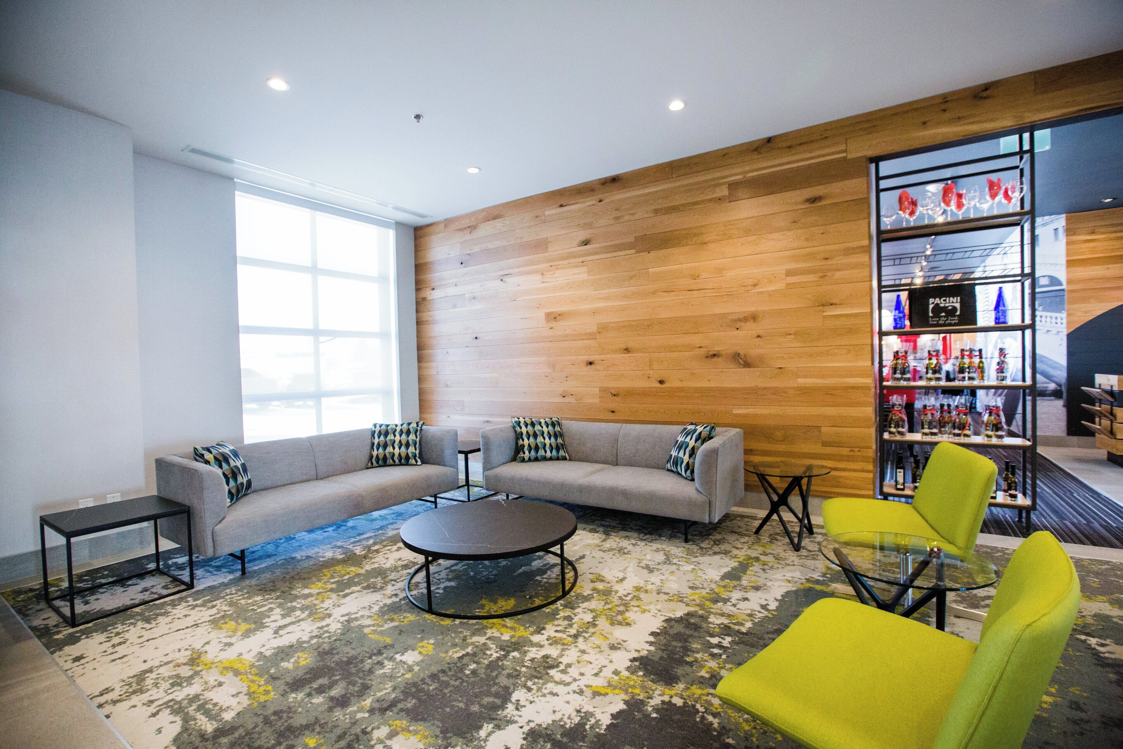 Un área de estar moderna con un sofá modular, una mesita de centro y un sillón amarillo brillante.