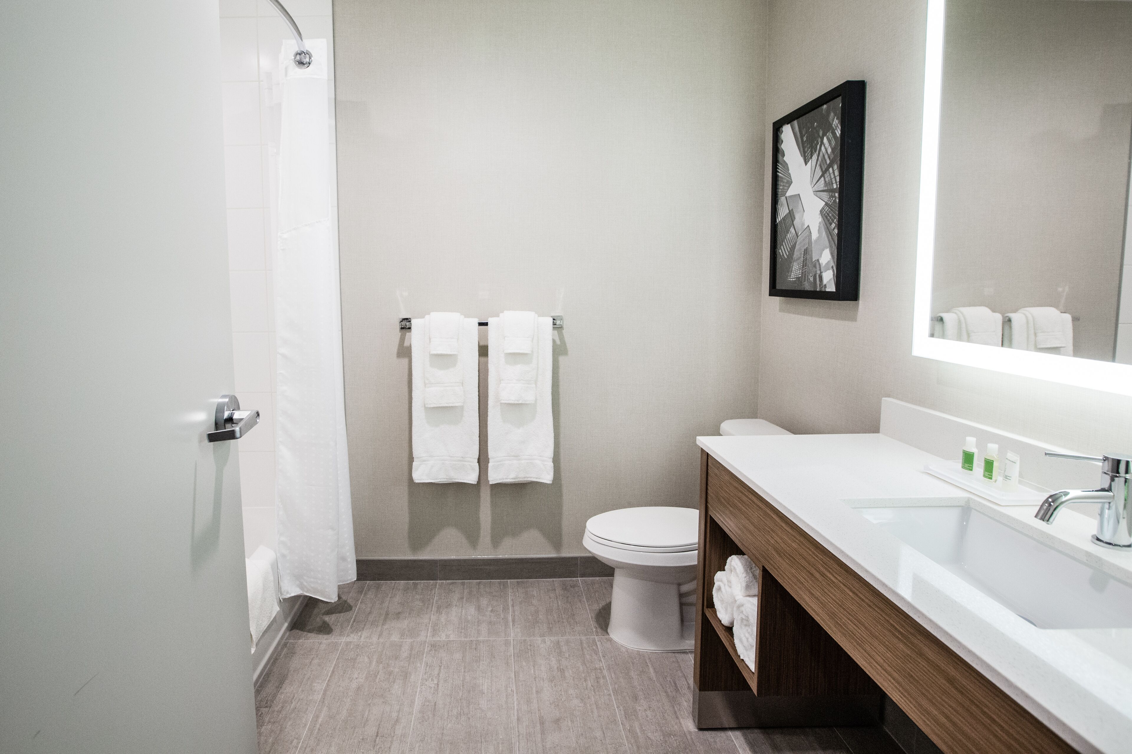A modern bathroom with a shower, toilet, and sink.