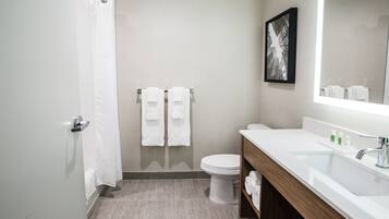 A modern bathroom with a shower, toilet, and sink.