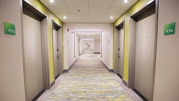 Corredor de hotel com portas numeradas 435 e 436, dando acesso aos quartos.