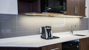 A modern kitchen with a built-in microwave, coffee maker, and dishwasher. - Holiday Inn Calgary South Conference Center by IHG (Calgary)
