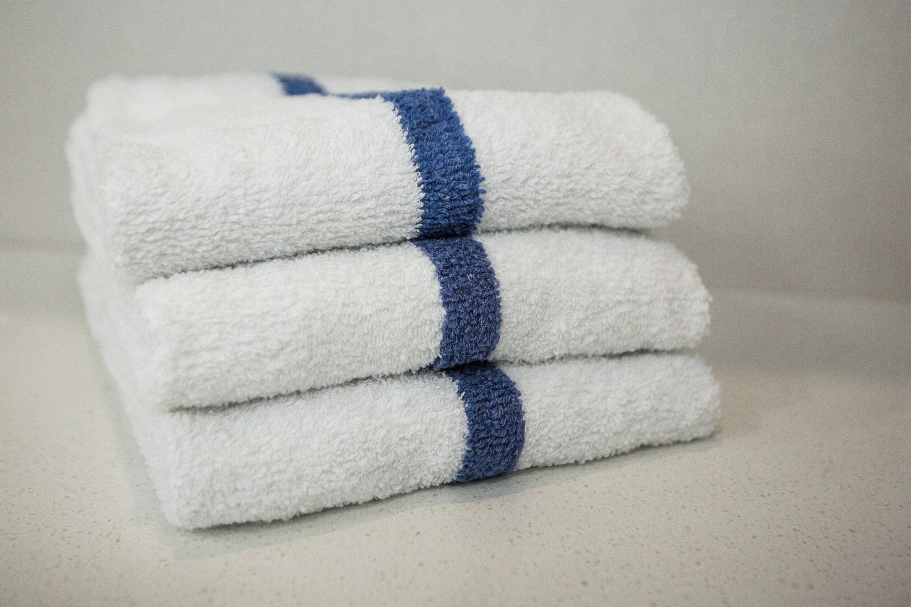 A stack of white towels with blue stripes.