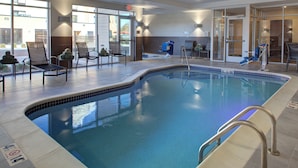 An indoor swimming pool with chairs and a changing room. - Fairfield Inn and Suites by Marriott Detroit Canton (Canton)