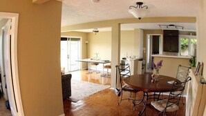 A dining area with a round table, chairs, and a chandelier. - Leigh Lani Guest House (Victoria)