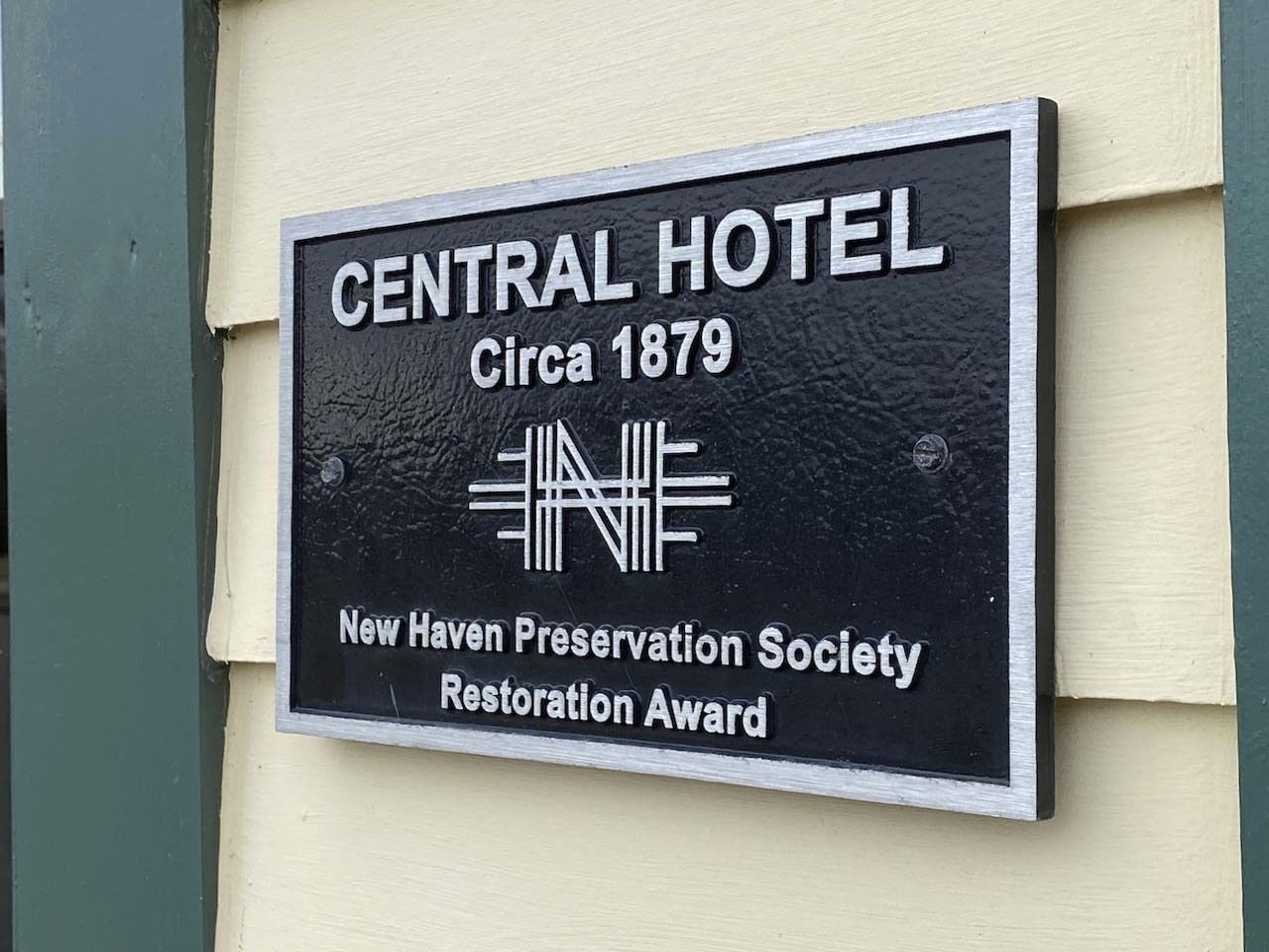 A sign for the Central Hotel, indicating it was established around 1879. The sign is awarded by the New Haven Preservation Society for restoration.