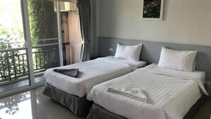 A hotel room with two beds, a balcony with a view, and a framed picture on the wall. - Rose Villa Resort (Pak Chong)