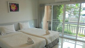 A hotel room with two beds, a large window with a view of greenery, and a painting on the wall. - Rose Villa Resort (Pak Chong)