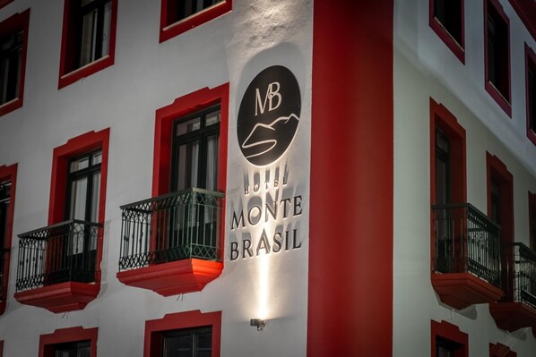 A hotel sign with balconies and red window frames. - Residencial Monte Brasil (Angra do Heroismo)