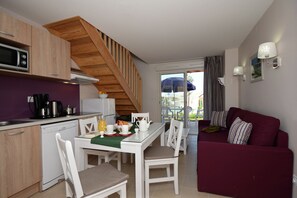 A compact living space with a kitchen, dining area, and a sofa. - Apartment in Le Paradou with Pool & Sauna (Paradou)