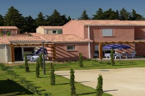 A residential building with a patio area, outdoor seating, and a small garden. - Apartment in Le Paradou with Pool & Sauna (Paradou)