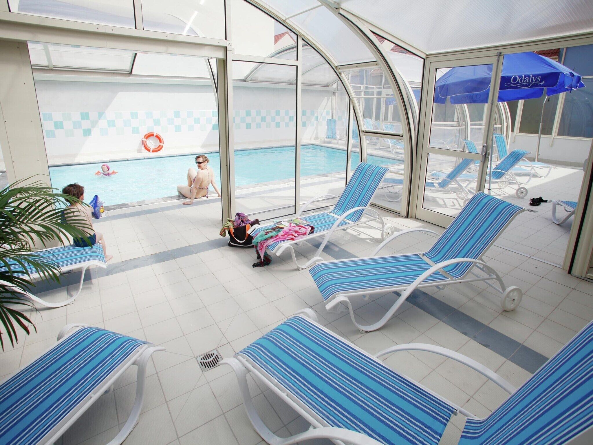 A covered pool area with lounge chairs and a poolside seating area.
