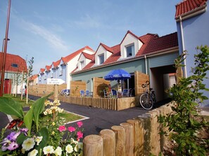 A row of houses with red-tiled roofs and a wooden fence in the foreground. - Spacious Coastal Apt w/ Garden (le Crotoy)