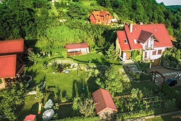 Zona residencial con varias casas, un jardín bien cuidado y un pequeño estanque.