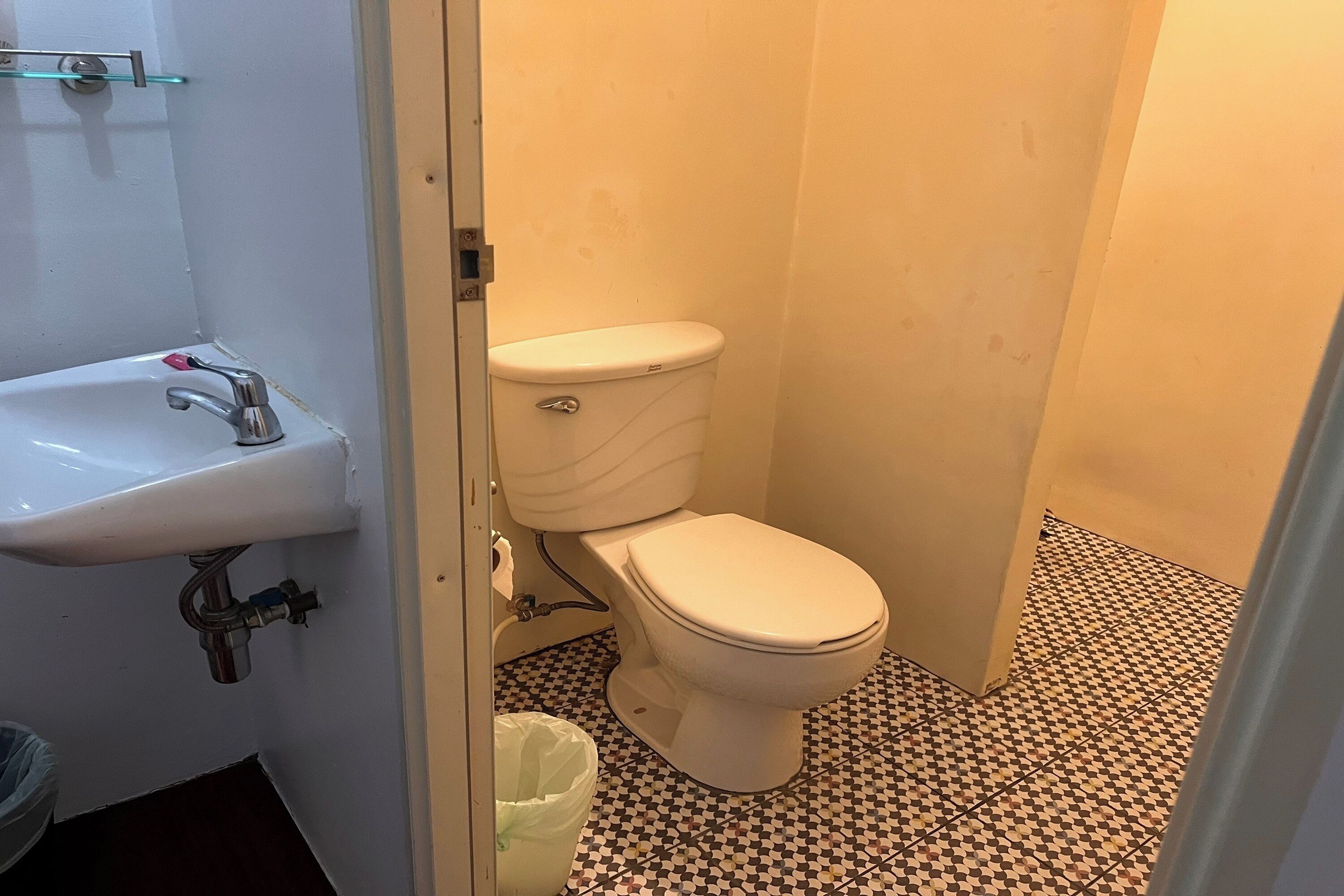 A small bathroom with a toilet, sink, and tiled floor.