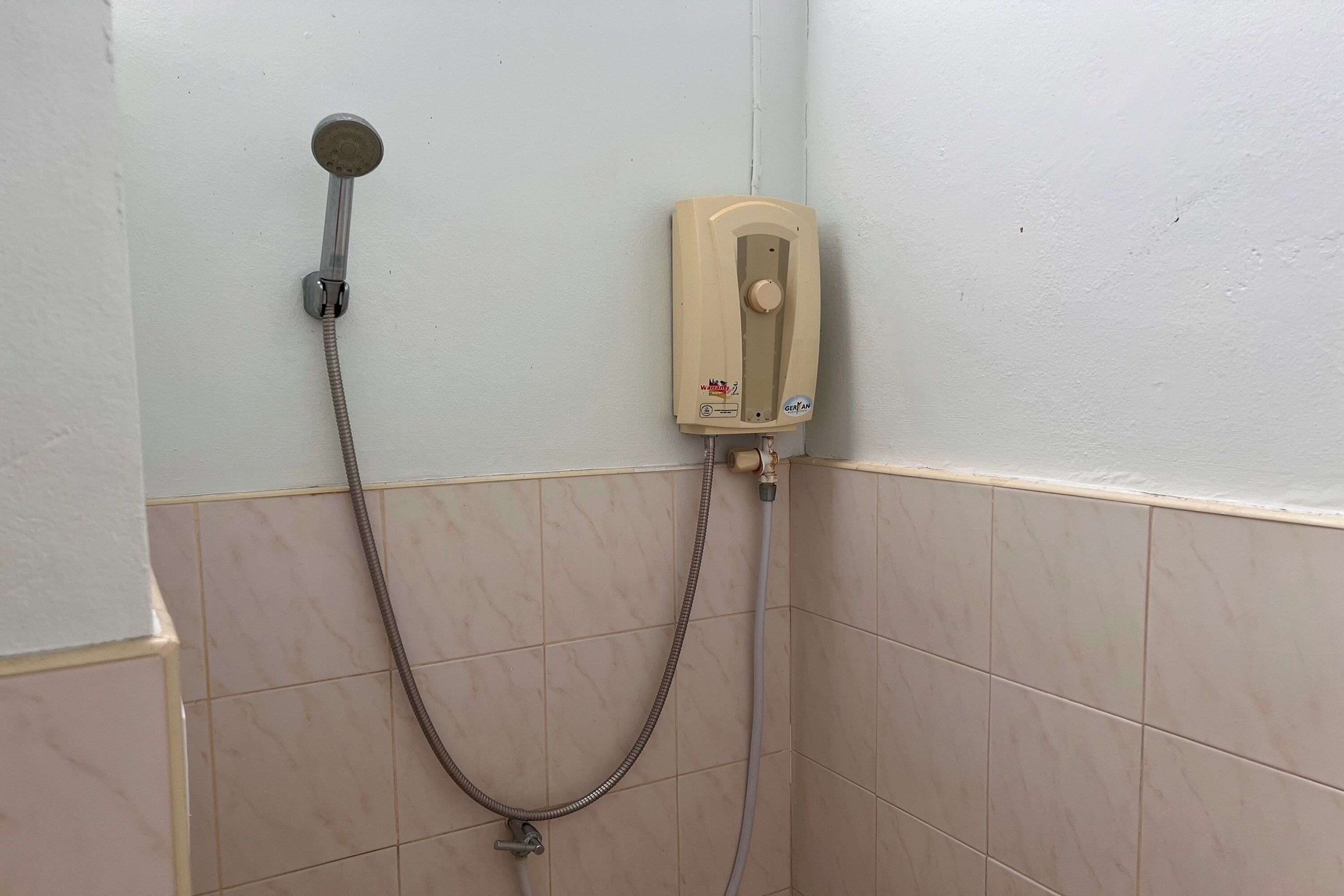 Doccia con soffione a mano e pannello di controllo a parete.