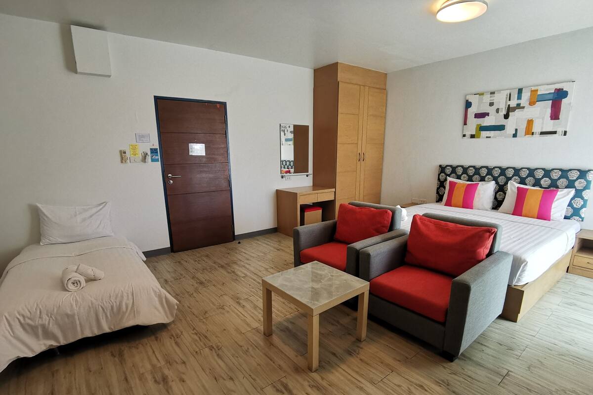 Una habitación de hotel con cama, escritorio, silla y una pequeña mesa.