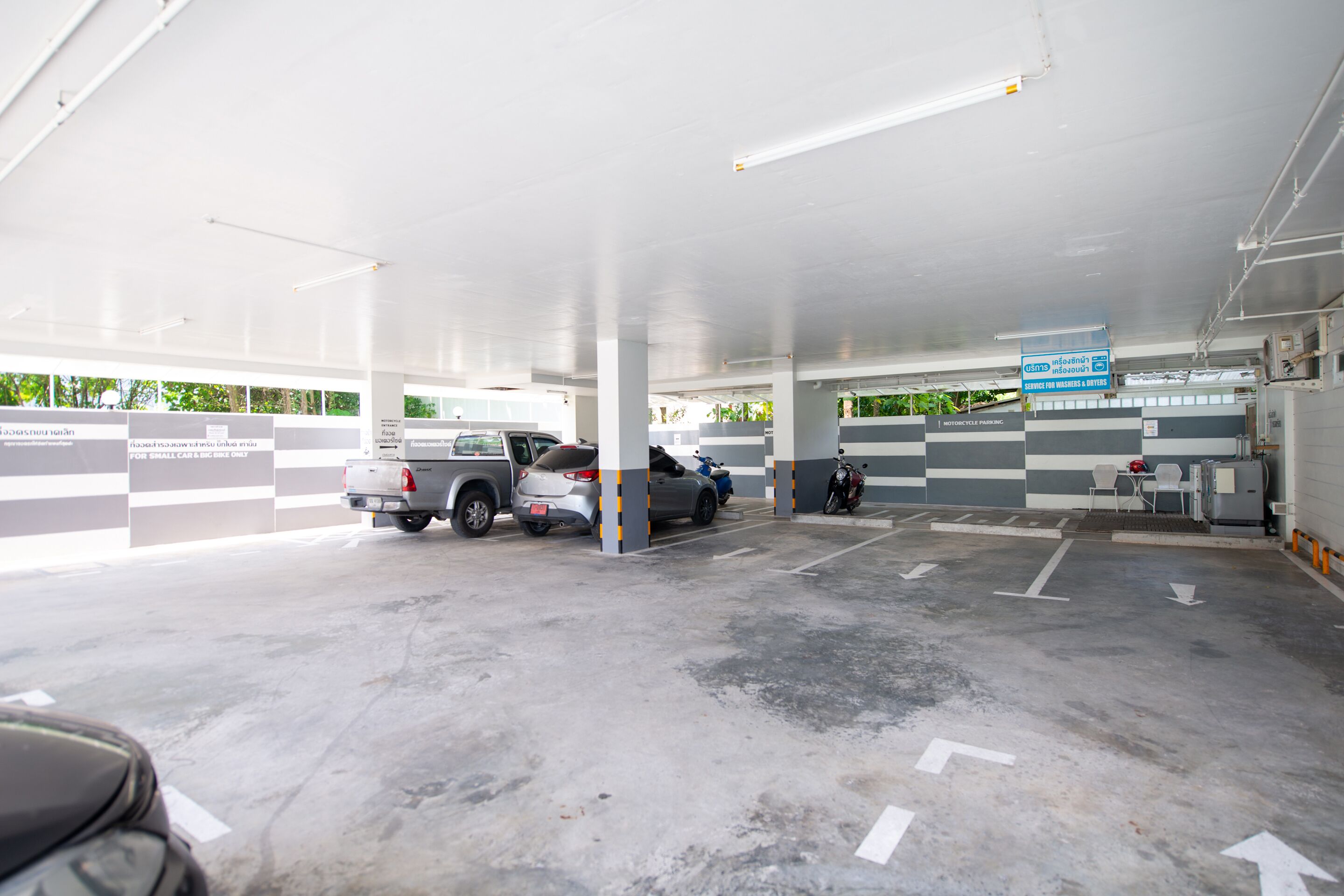 A multi-level parking garage with clearly marked parking spaces and directional arrows on the floor.